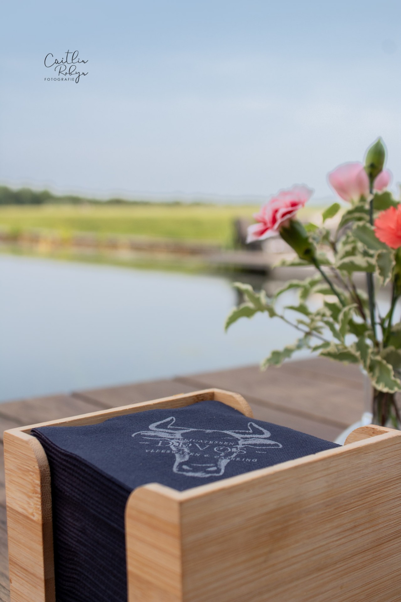 Servettenhouder met bloemen bij een event aan het water